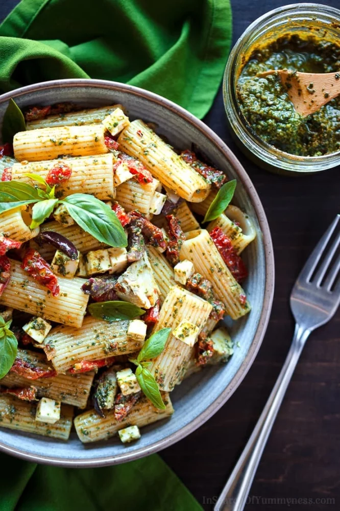 A bowl of pasta with pesto, sundried tomatoes, olives and feta cheese | InSearchOfYummyness