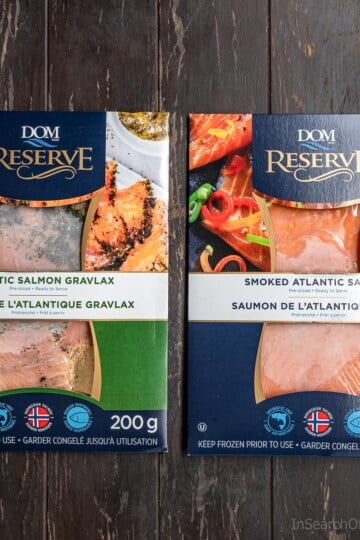 Two packages of cured salmon sitting on a table top. One is Atlantic salmon gravlax and the other is smoked Atlantic salmon.
