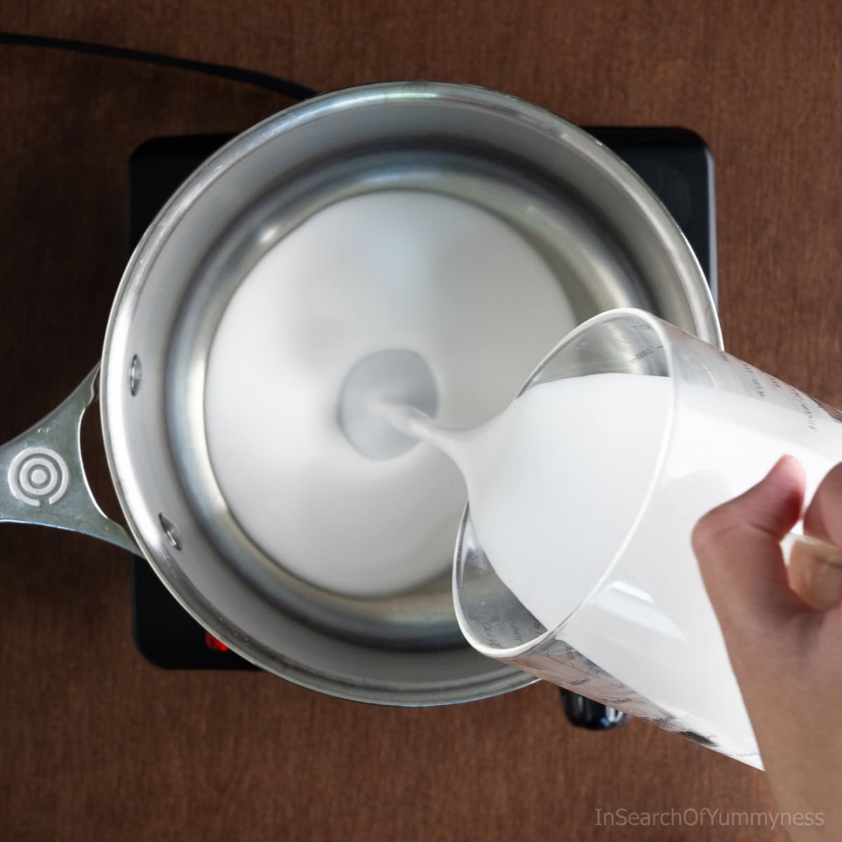 Pouring coconut milk into a saucepan.