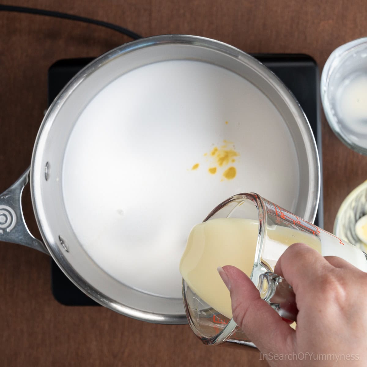 Pouring condensed milk into a saucepan.