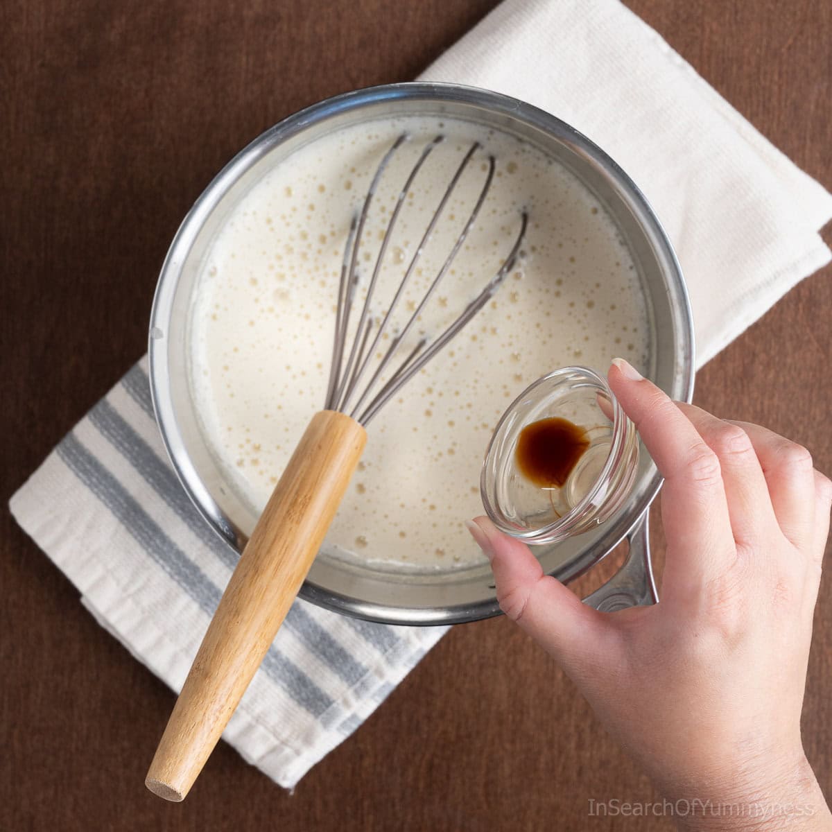 Adding vanilla extra to the ice cream mixture off the heat.