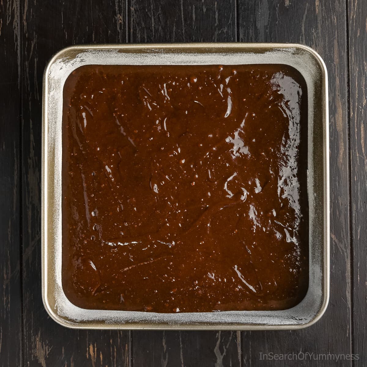 A 9 by 9 metal baking dish with fully baked brownies in it.