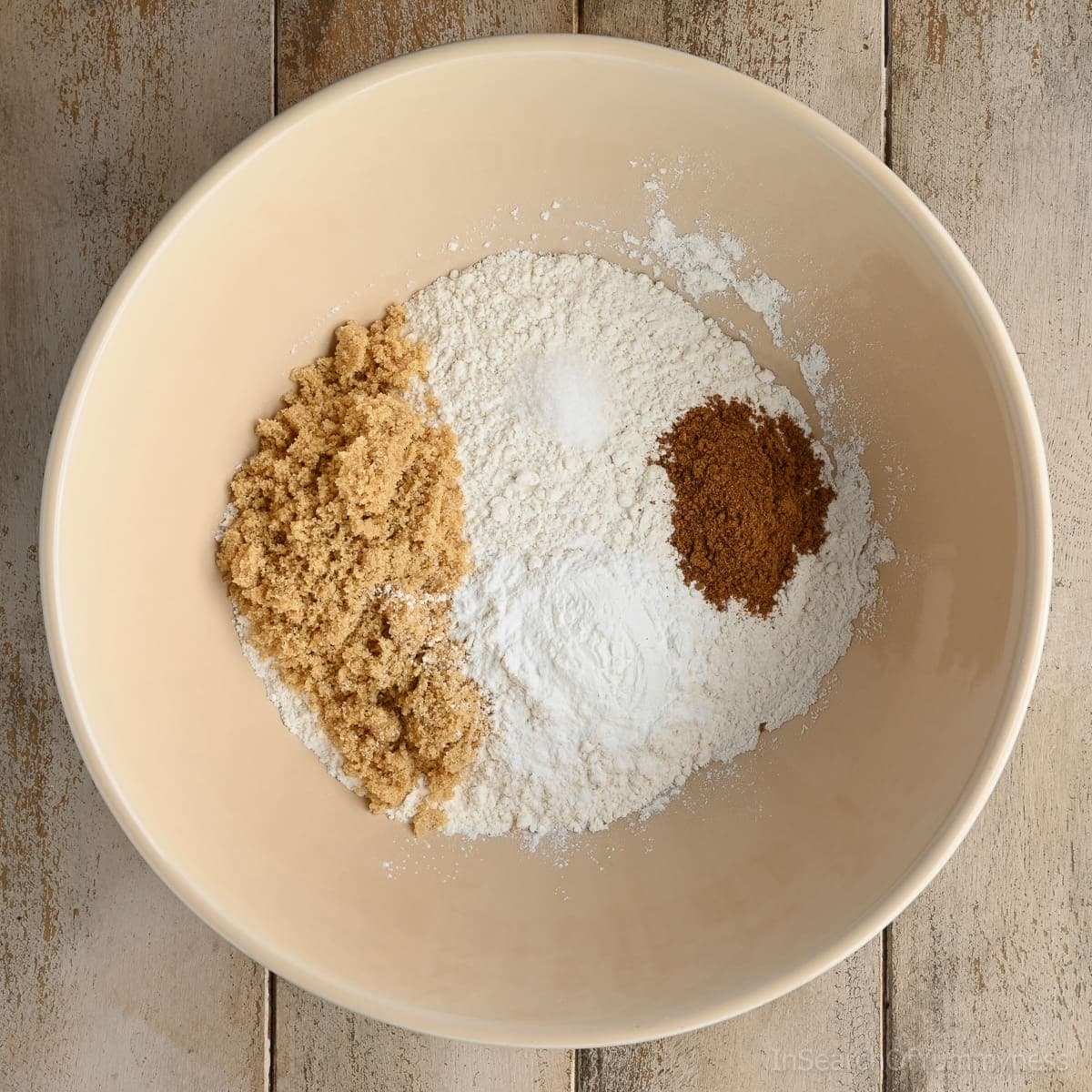The dry ingredients for pecan pumpkin waffle batter in a peach-coloured bowl, waiting to be mixed together.