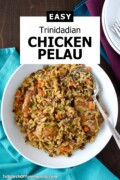 A bowl of Trinidadian chicken pelau made with rice, pigeon peas, and carrots. The dish has a rich brown colour and is served with a spoon, teal napkin, and dark wood background. Text on image reads “Easy Trinidadian Chicken Pelau” with the website name InSearchOfYummyness.com.