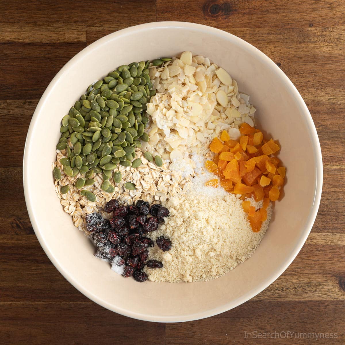 Dry ingredients for homemade granola in a large white mixing bowl.