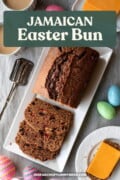 A white platter with slices of freshly baked Easter Bun, next to a saucer with slices of cheese. Text overlay says "Jamaican Easter Bun".f