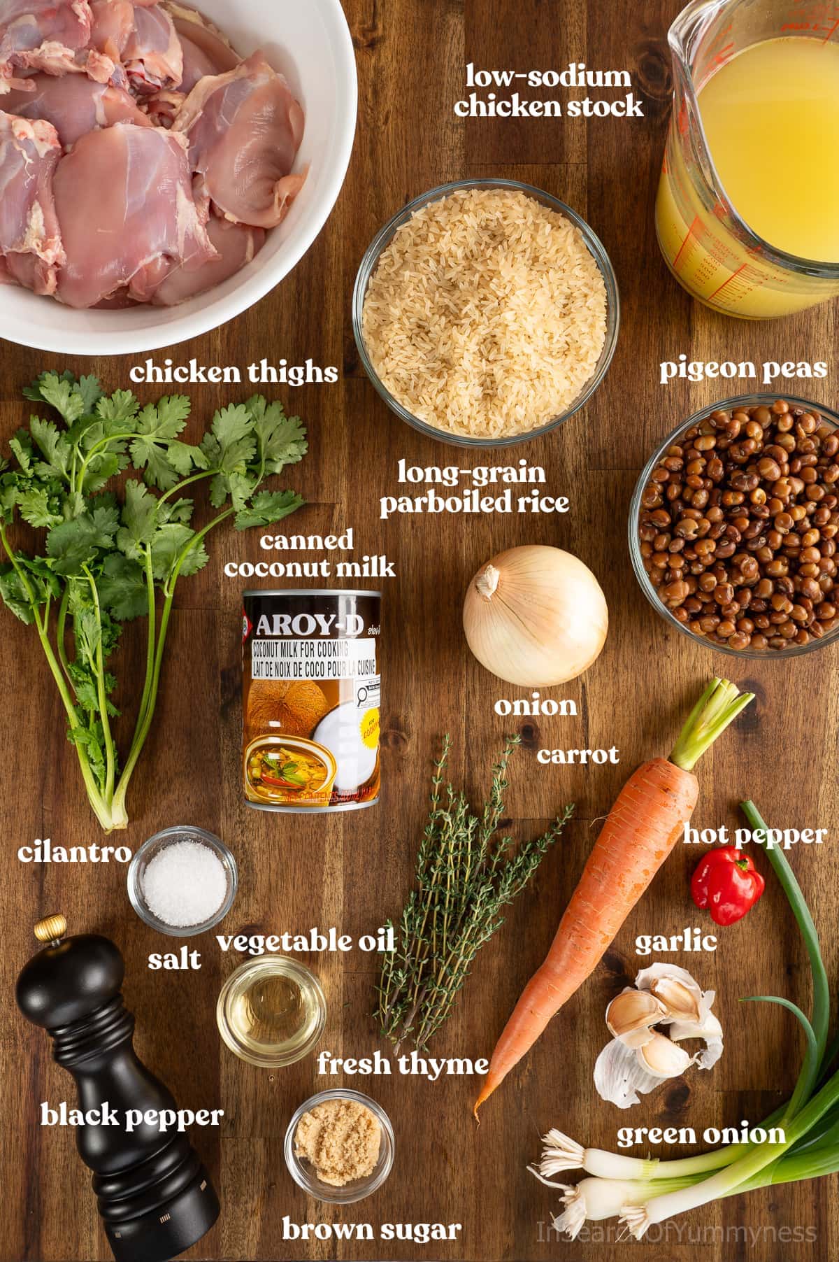 Ingredients needed to make Trinidad pelau with chicken and pigeon peas, including rice, coconut milk, chicken stock, vegetables and seasonings.