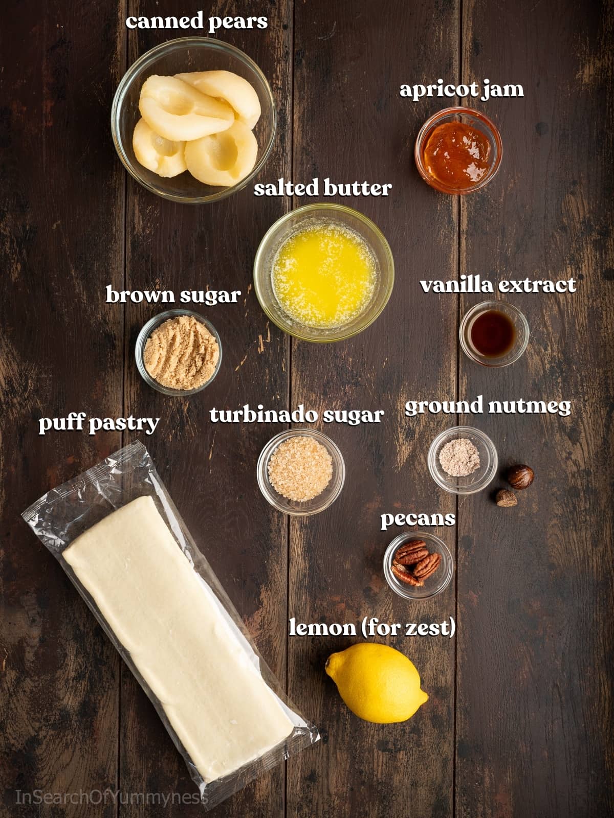 Ingredients for spiced pears in puff pastry with canned pears, store-bought puff pastry and more on a wooden table.