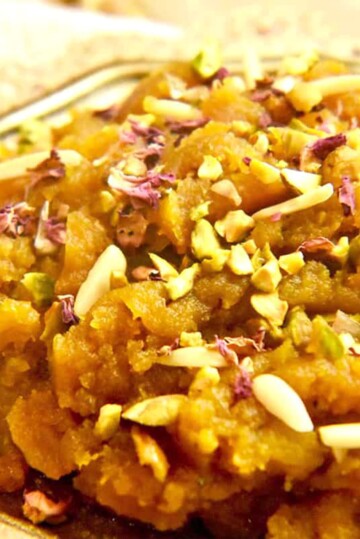 Pumpkin halwa, a Pakistani dessert made with pumpkin, milk, and ghee, flavoured with cardamom and topped with chopped pistachios, almonds and rose petals.