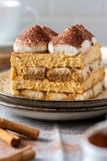 A tall slice of pumpkin tiramisu on a plate.